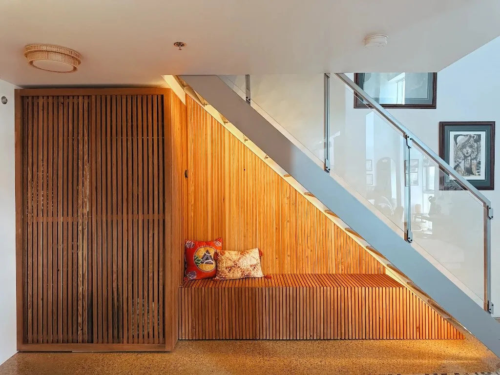 Custom slatted timber cabinet and bench built under a modern staircase